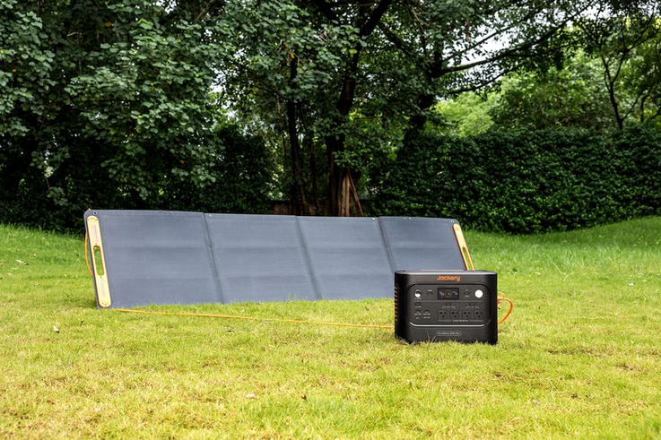 Portable solar panel connected to a portable power station on grass