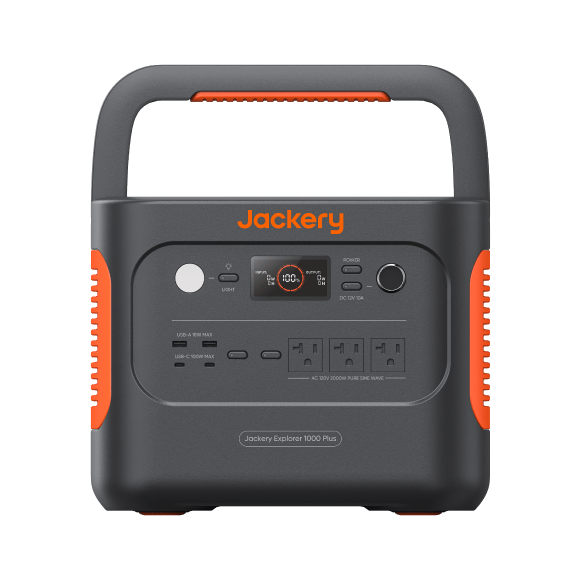 Jackery Explorer 1000 Plus portable power station, front view showing the folding carry handle, the light button and round status display, the power button and 12 V car socket on the right, USB-A and USB-C ports on the lower left, and three AC outlets, on a grey body with orange side vents.