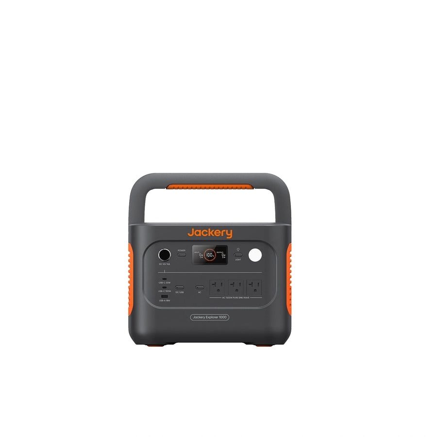 Jackery Explorer 1000 v2 portable power station, front view showing the folding carry handle, the 12 V car socket and power button, the round status display, the light button, USB-C and USB-A ports on the left, and three AC outlets on the right, on a grey body with orange side vents.